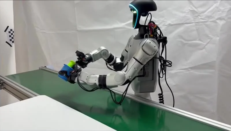 Unitree G1 humanoid grasping a cup beside a conveyor, the dynamic task where Long-WAM world-action model context beats baselines